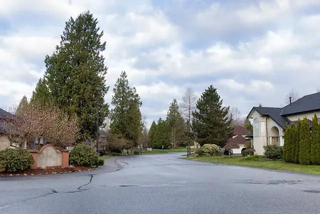 Wide asphalt driveway and turnaround beside a house