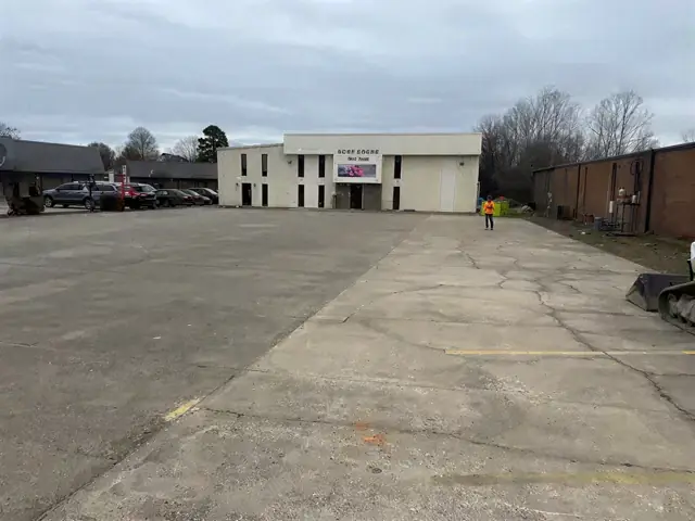 Empty asphalt parking lot in front of a low commercial building