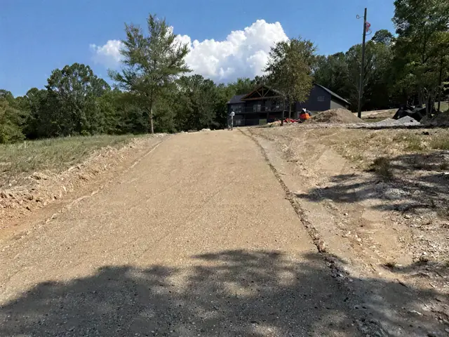 Graded gravel base for a driveway beside a rural home