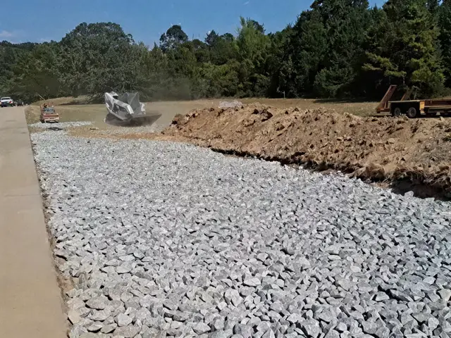 Crushed stone base piled along a new driveway cut