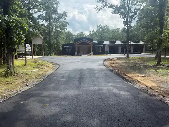 Finished asphalt driveway leading up to a house